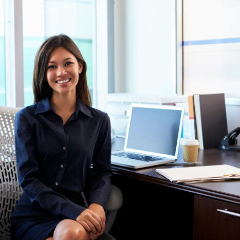 Smiling woman sitting at an office desk.